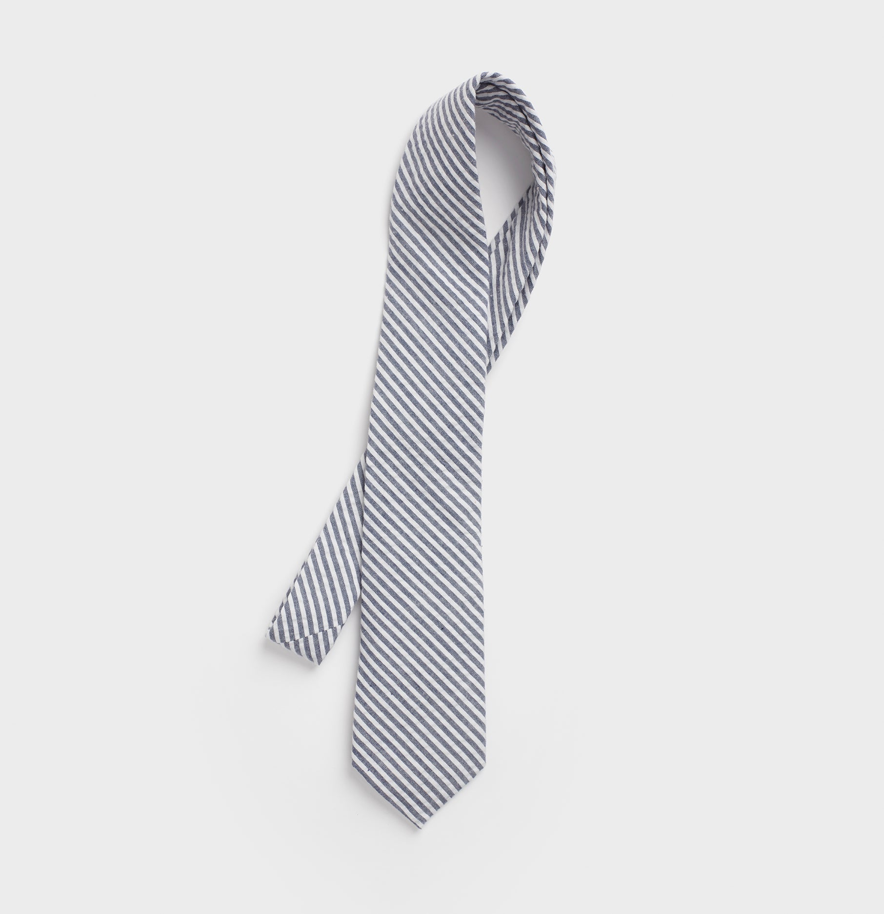 https://static.theblacktux.com/products/neckwear/navy-white-seersucker-necktie/1_Necktie_LightBlue_WhiteStriped_1_1812x1875.jpg